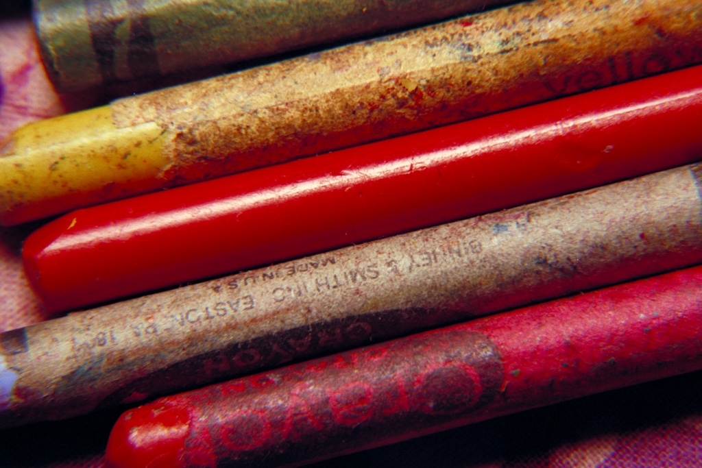 Crayons photograph. Old Crayola crayons, with the peel on. Dirty and worn. Red and yellow.