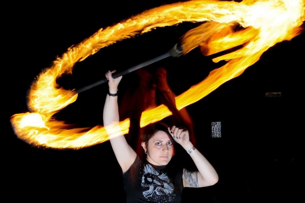 Fire Spinners photograph. I used a setup with rear-synch flash and longer exposure, to that I could get the motion of the fire and also a still image of the person at the same time.  See the <a href='/technology/rear-sync-flash-photography/'>full explanation of rear-curtain flash.</a>