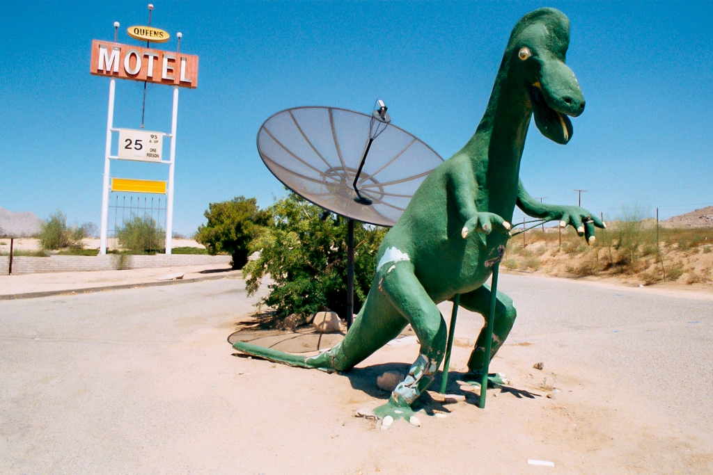 Road trip across America photograph. I'm not sure what's going on here. Why is there a dinosaur? Is he a bad decision dinosaur? Room rates are pretty good but this place would give me the creeps.