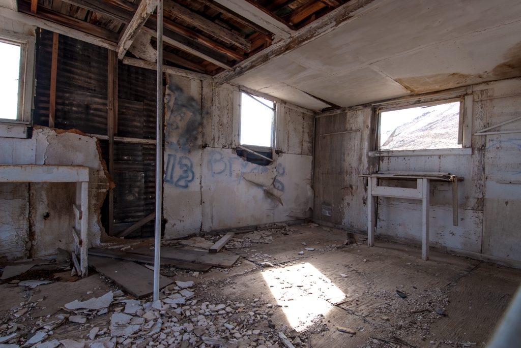 Death Valley, California photograph. Interior of a mostly-white building with graffiti. I love the bits of wall spilled all over the floor. I wonder what this house looked like new.