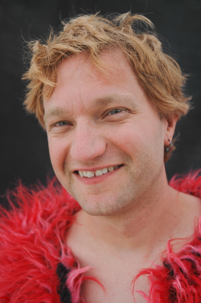 Burning Man 2004 photograph. I love the exuberance of this guy's smile. Also, his festive feather-like costume. 