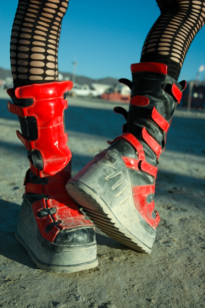 Feet and Shoes photograph. Nice bright red. I like the holy stockings, and the straps on the boots. They look like motorcycle gear.