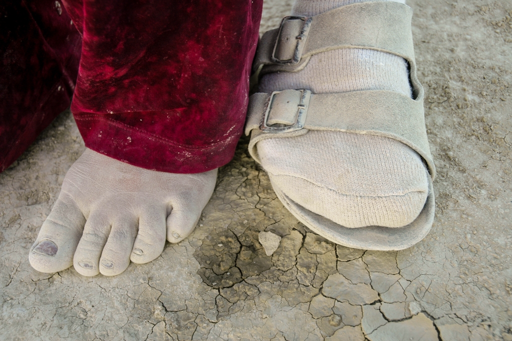 Feet and Shoes photograph. I love the red velvet pants against nearly-white dusted-out feet, and cracked dusty earth.