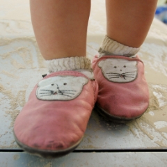 Baby feet in pink kitty shoes