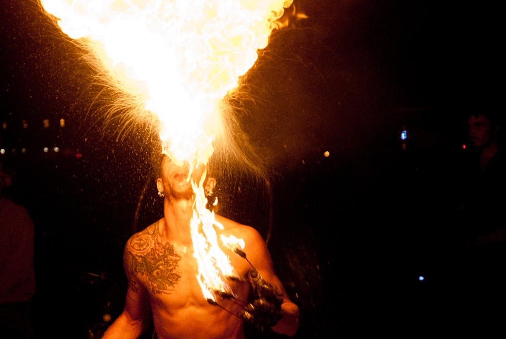 Fire Spinners photograph. I believe he sucks in a little fuel and then spits out the flame
